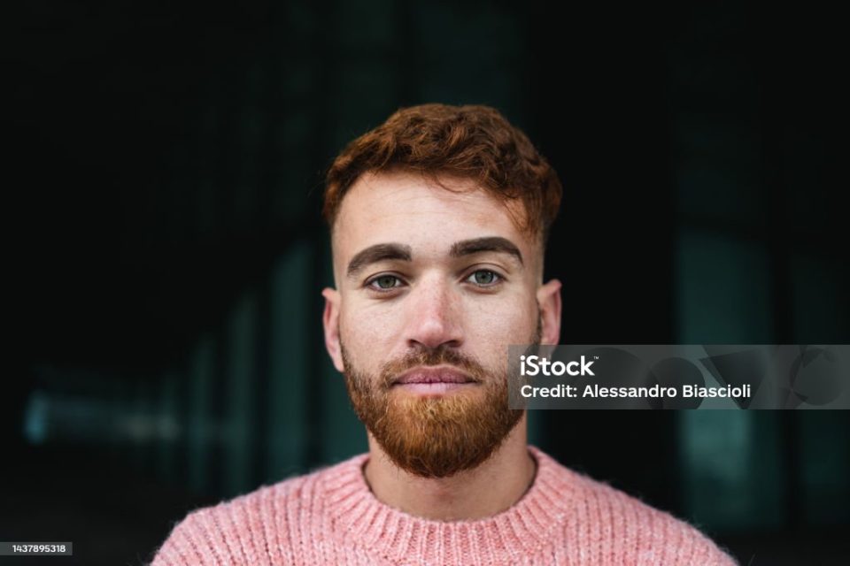 Portrait of young man with red hair looking at the camera